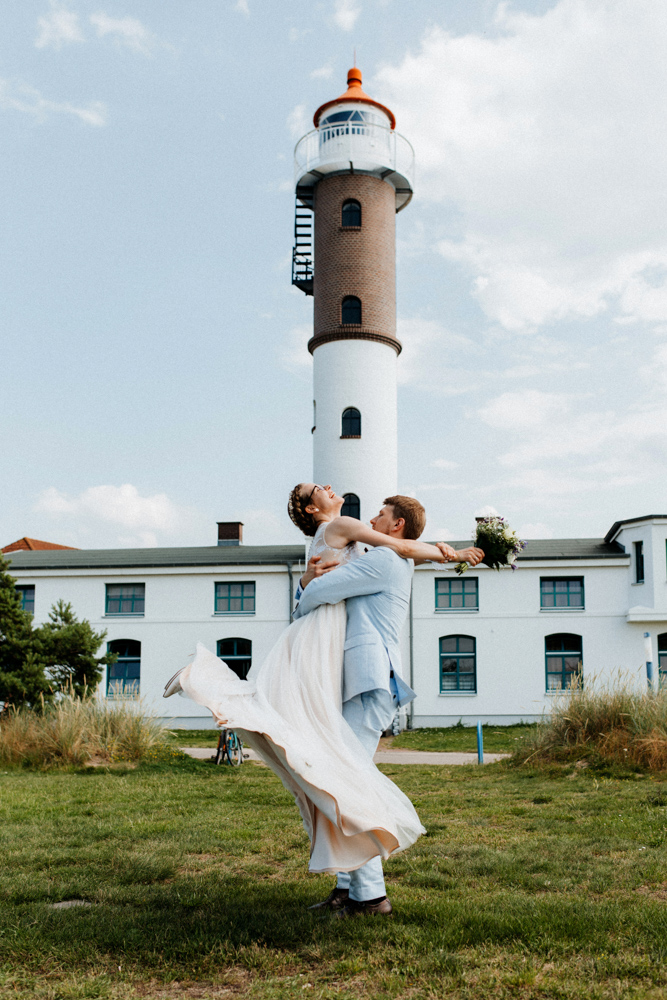 Hochzeit Shooting am Timmendorfer Strand an der Ostsee. Bräutigam hebt Braut hoch und dreht sich.